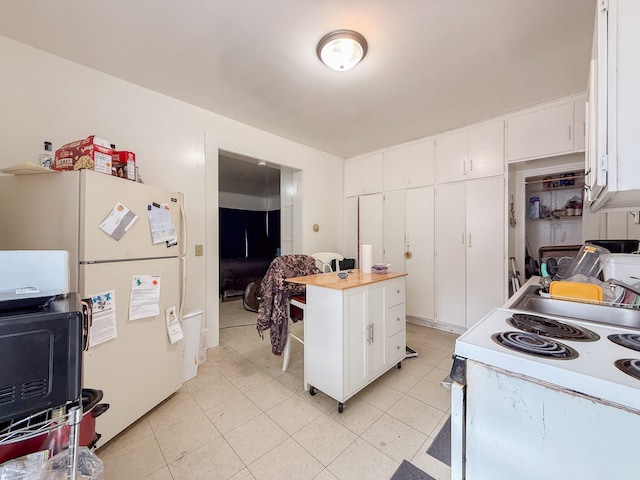 kitchen featuring light countertops, white appliances, white cabinets, and light tile patterned floors