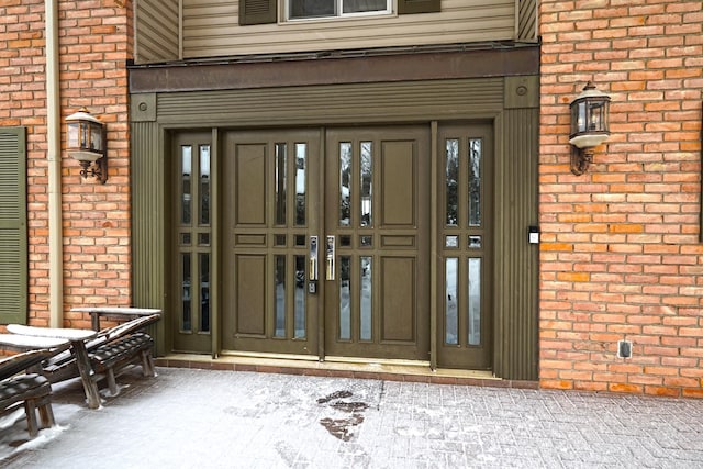 view of exterior entry featuring brick siding