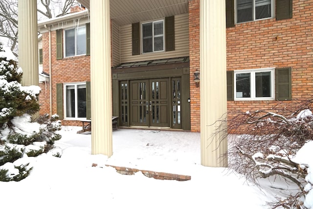 snow covered property entrance with french doors