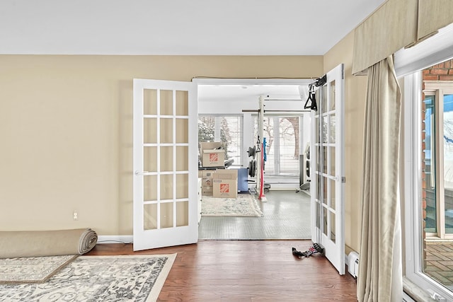 doorway to outside featuring baseboard heating, dark wood finished floors, and french doors