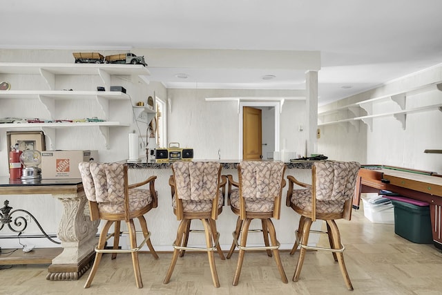 kitchen with open shelves and a kitchen breakfast bar