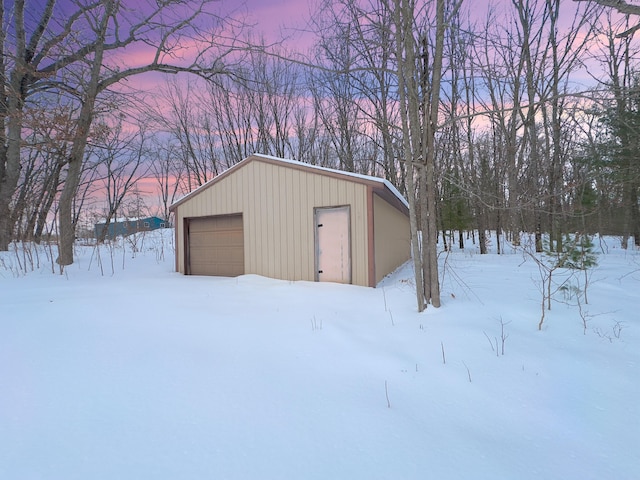 snow covered structure with an outbuilding