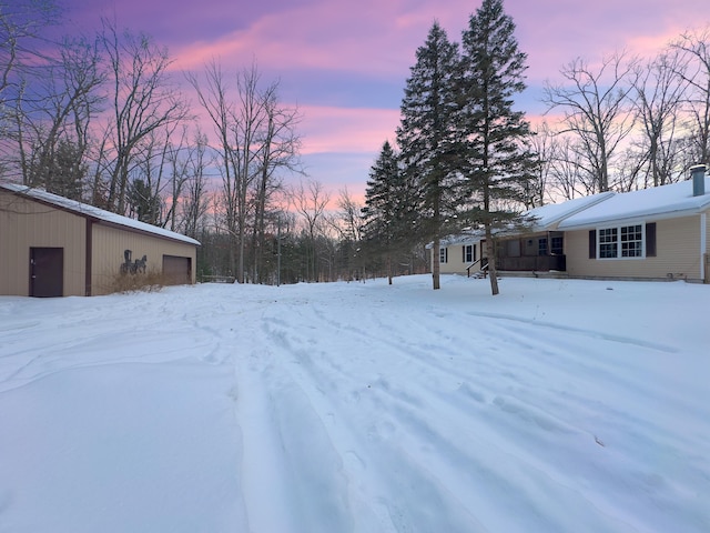 snowy yard featuring a garage