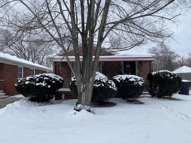 view of snow covered exterior featuring brick siding