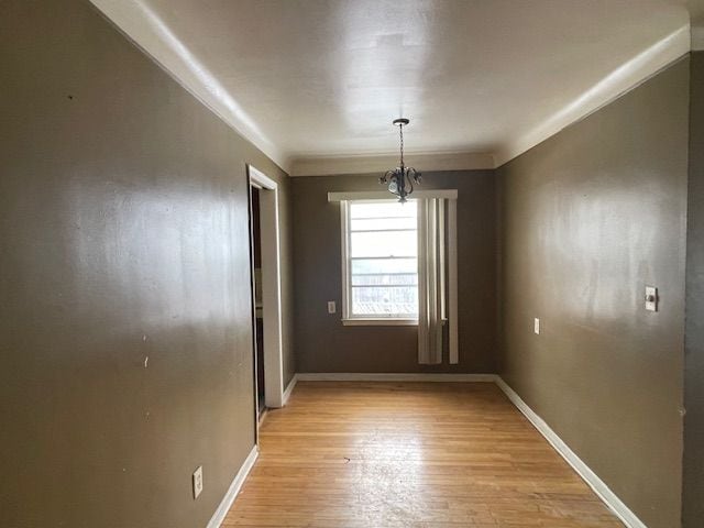 unfurnished dining area with light wood-type flooring and baseboards