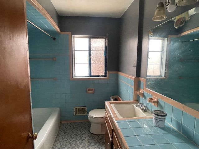 bathroom with toilet, tile walls, visible vents, and a wealth of natural light