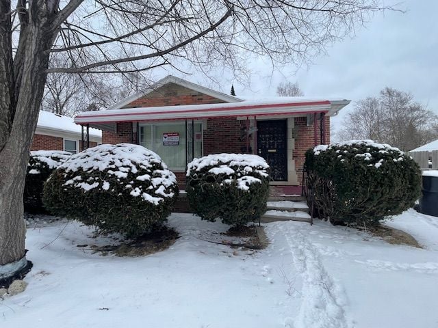 bungalow-style house with brick siding