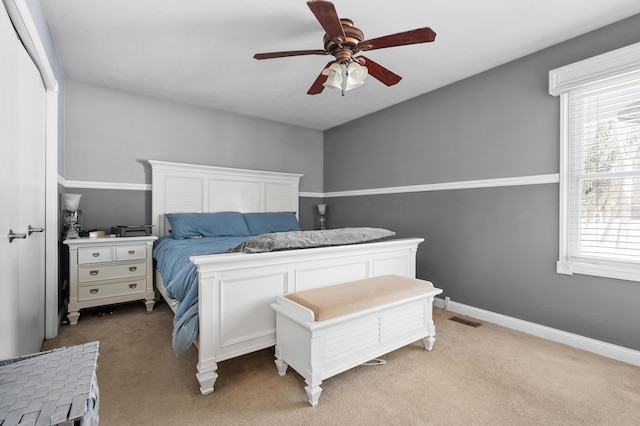 bedroom with baseboards, a ceiling fan, visible vents, and light colored carpet