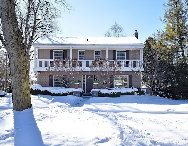 view of front property with brick siding and a chimney