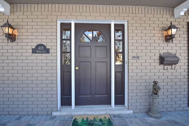 property entrance featuring brick siding