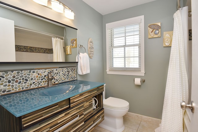 bathroom featuring tile patterned flooring, baseboards, vanity, and toilet