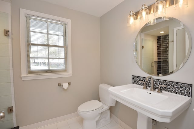 bathroom featuring a sink, tile patterned flooring, toilet, and baseboards