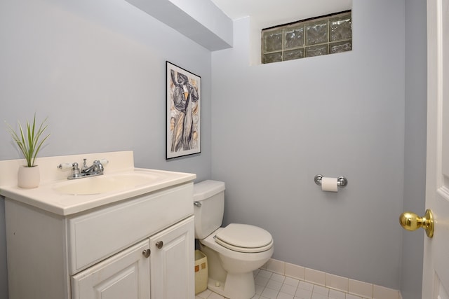 bathroom with toilet, baseboards, vanity, and tile patterned floors