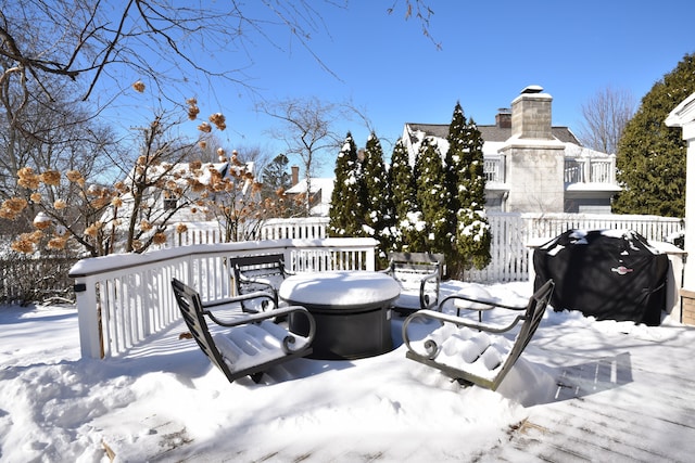 snow covered deck with fence and area for grilling