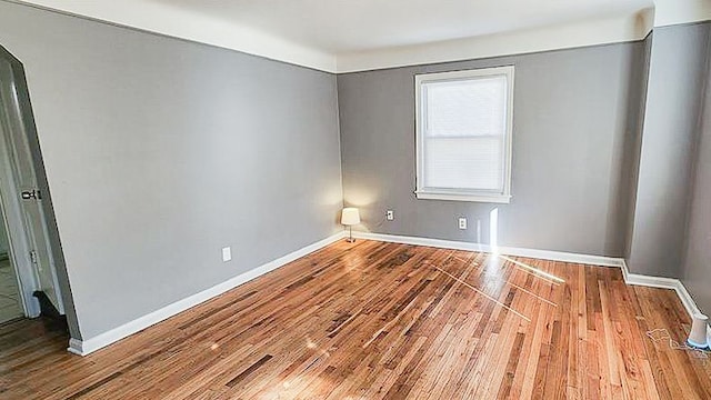 empty room featuring baseboards and wood finished floors