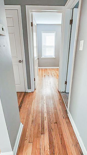 hall with light wood finished floors and baseboards