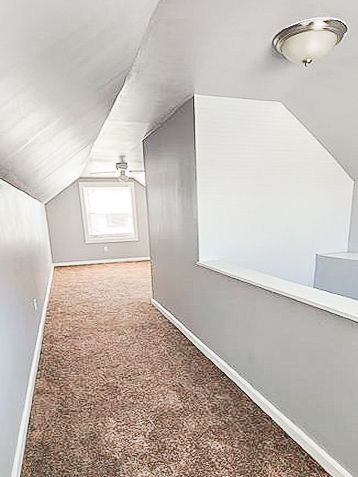 bonus room featuring carpet floors, baseboards, and vaulted ceiling