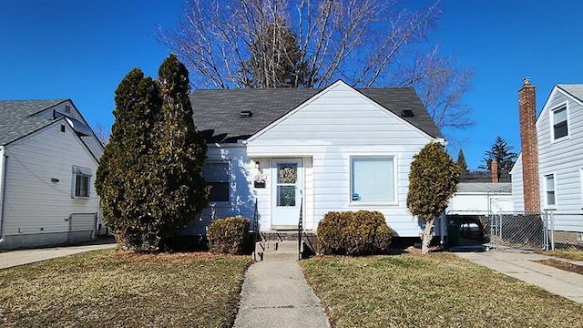 view of front of property featuring central AC unit, fence, a front lawn, and concrete driveway