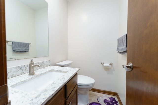 bathroom featuring baseboards, vanity, toilet, and tile patterned floors