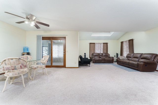 living area featuring lofted ceiling, ceiling fan, baseboards, and light colored carpet