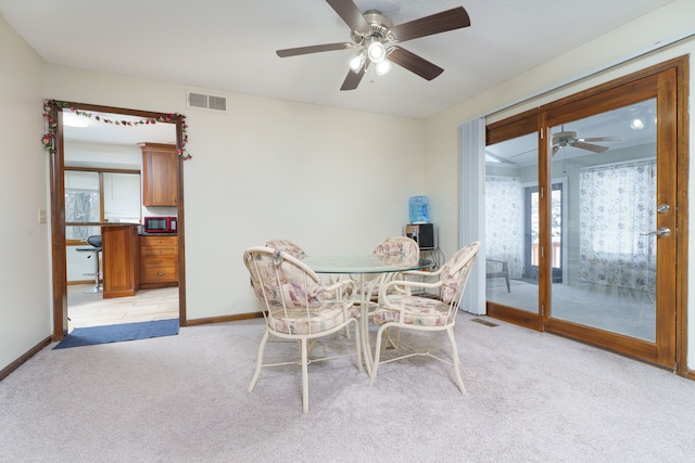 dining room with light carpet, visible vents, and baseboards