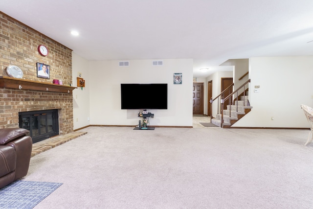 living room with stairway, baseboards, a brick fireplace, and visible vents