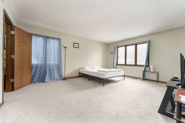 bedroom featuring a textured ceiling, carpet flooring, and baseboards