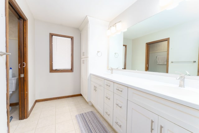 full bath with double vanity, tile patterned flooring, a sink, and baseboards