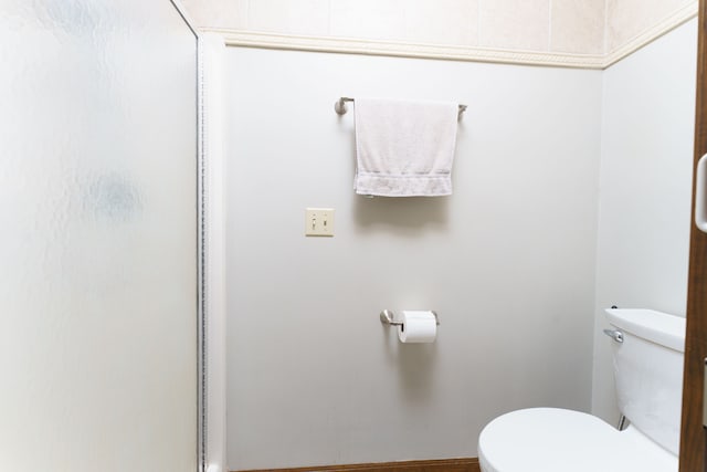 bathroom with a shower with shower door and toilet