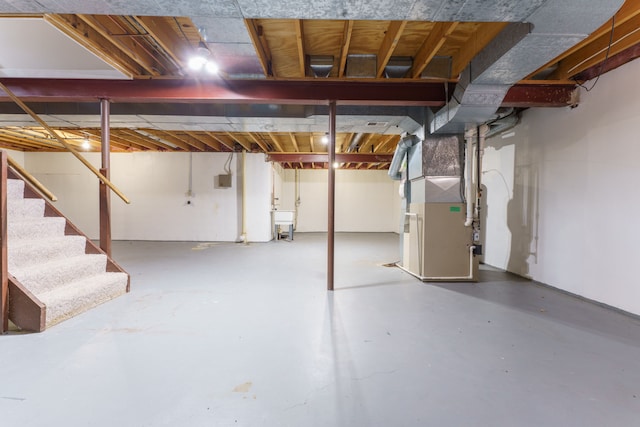 unfinished basement with heating unit and stairs