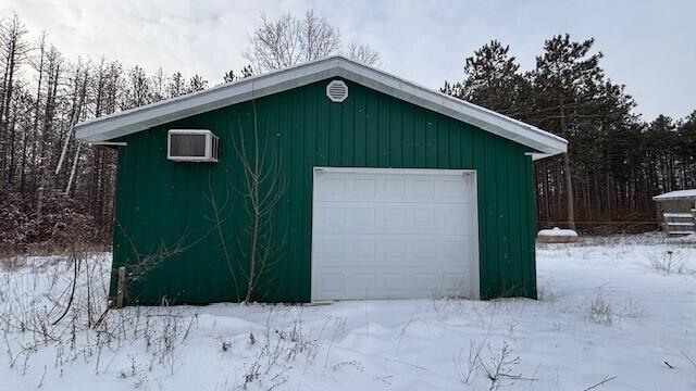 snow covered garage featuring a detached garage