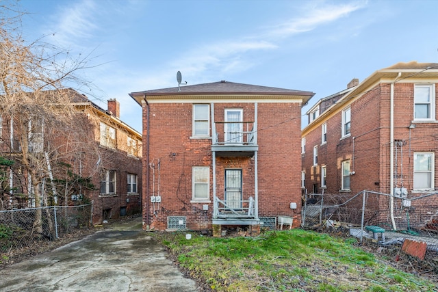 back of property featuring fence and brick siding