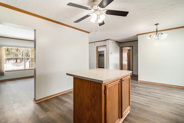 kitchen with hanging light fixtures, brown cabinetry, light countertops, and wood finished floors