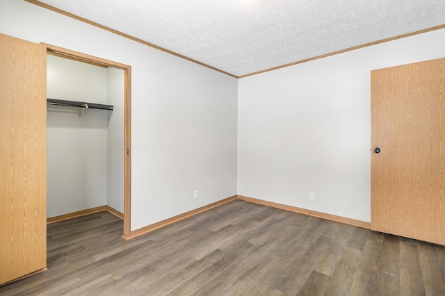 unfurnished bedroom with baseboards, dark wood finished floors, ornamental molding, a textured ceiling, and a closet