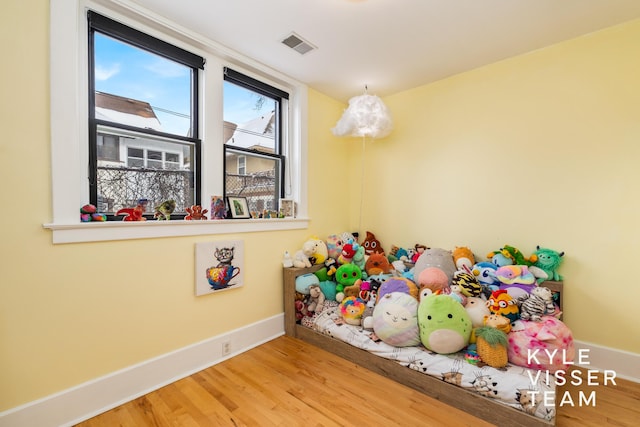 playroom featuring baseboards, visible vents, and wood finished floors