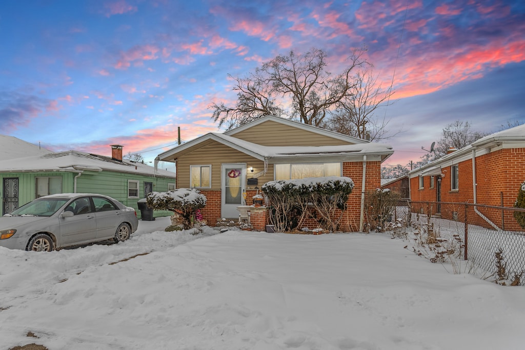 view of front of property featuring brick siding and fence