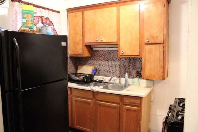 kitchen featuring black appliances, brown cabinets, light countertops, and decorative backsplash