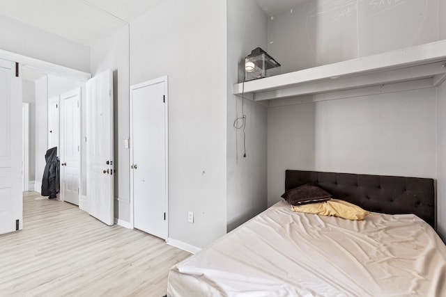 bedroom with light wood-type flooring and baseboards