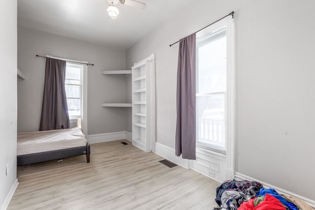 bedroom with light wood-type flooring, visible vents, and baseboards