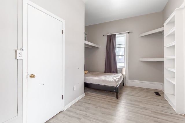 bedroom featuring light wood-type flooring, baseboards, and visible vents