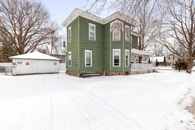 snow covered property featuring covered porch