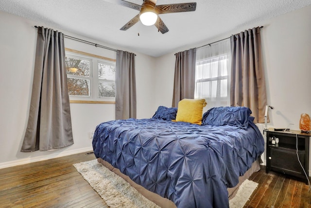 bedroom featuring a textured ceiling, dark wood-type flooring, and baseboards