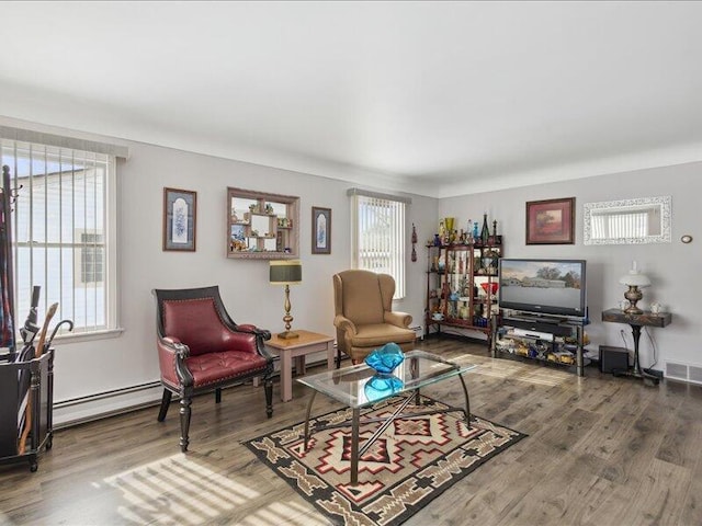 living room with a baseboard radiator, wood finished floors, and visible vents