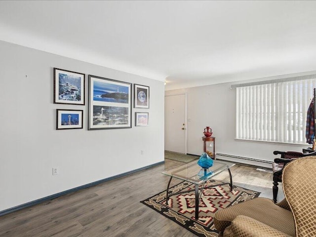 living area featuring a baseboard radiator, baseboards, and wood finished floors