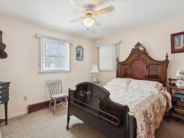 bedroom featuring light carpet, multiple windows, a ceiling fan, and baseboards