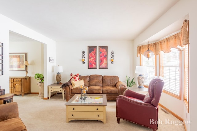 living room with visible vents, baseboards, and light colored carpet