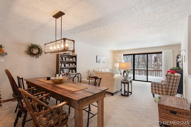 dining room featuring light carpet, baseboards, and a textured ceiling