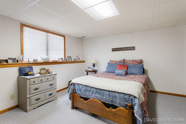 bedroom with light carpet, baseboards, and a paneled ceiling