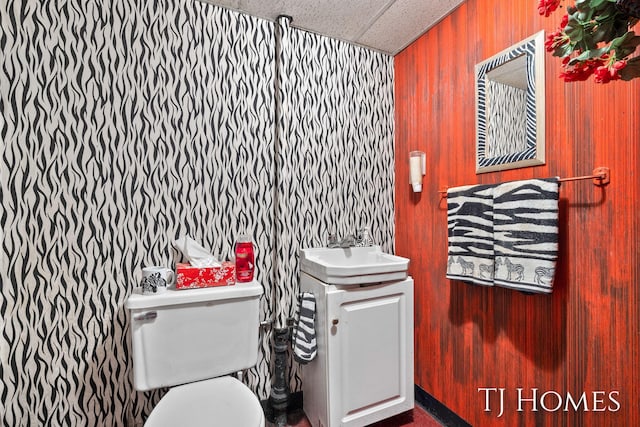 bathroom with toilet, a drop ceiling, and vanity