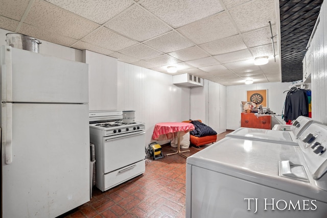 clothes washing area featuring brick floor, laundry area, visible vents, and washer and clothes dryer